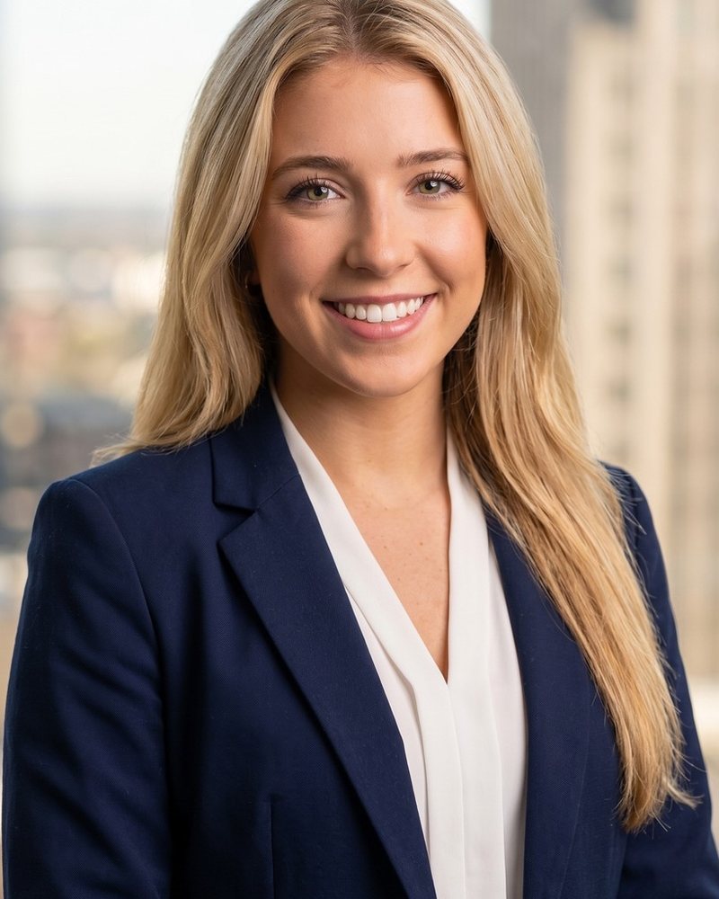 Portrait of Brooke Halvorsen in a navy blazer by an office window in Denver